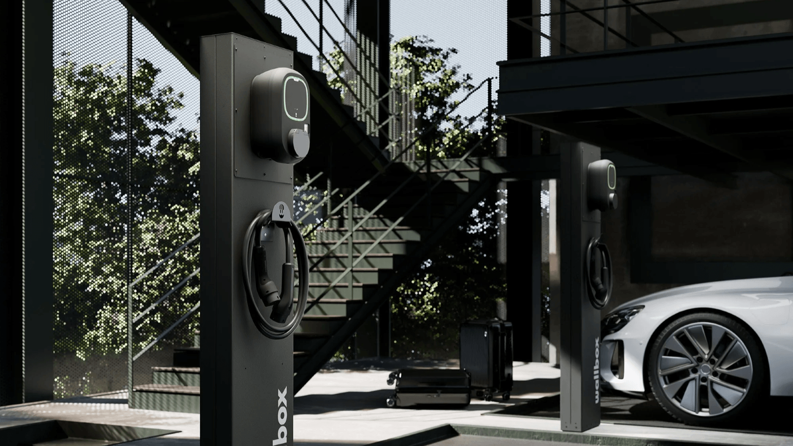 Zwei moderne Ladesäulen für Elektroautos in einem architektonisch gestalteten Außenbereich.