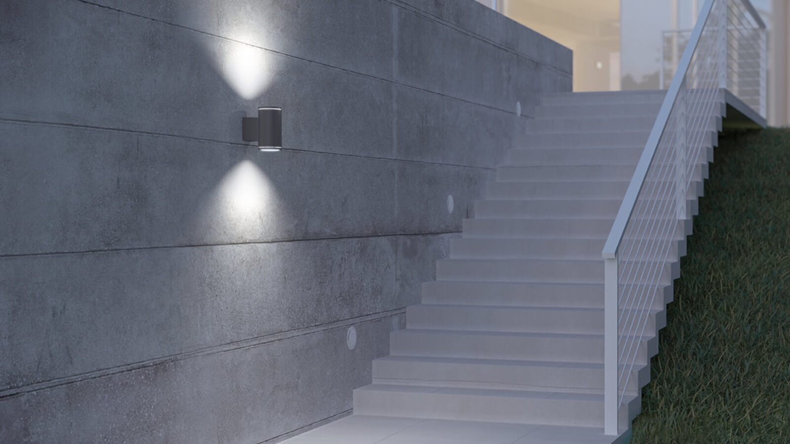 Das Bild zeigt eine Treppe mit Geländer. An der Wand neben der Treppe ist eine Wandleuchte befestigt deren Licht nach oben und unten ausstrahlt.