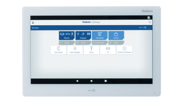 Das Bild zeigt ein weißes LUXORplay-Touchscreen-Display von theben. Es ist an der Wand montiert und zeigt eine benutzerfreundliche Oberfläche mit verschiedenen Steuerungsoptionen wie „Gute Nacht“, „Gute Morgen“, „Party“, „TV“ und „Telefonkommunikation“. Auf dem Display wird eine Temperatur von 23°C angezeigt.