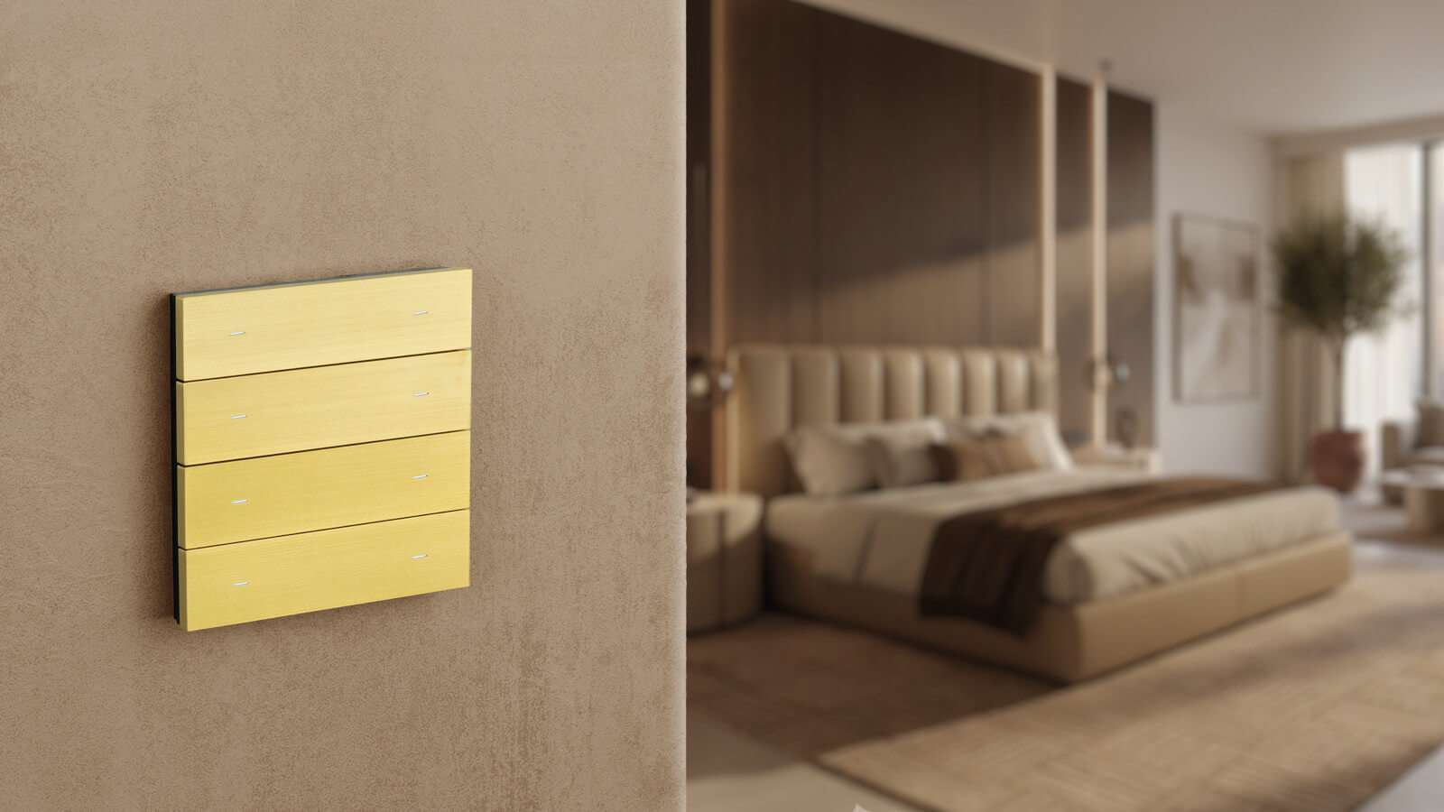 Ein messingfarbener Theben iONprime-Schalter ist an einer Wand im Schlafzimmer montiert. Im Hintergrund ist ein modern eingerichteter Raum mit Bett und warmen Holzelementen zu sehen.