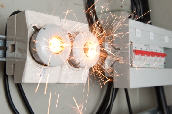 Das Bild zeigt eine elektrische Anlage mit Kabeln aus denen Funken sprühen.