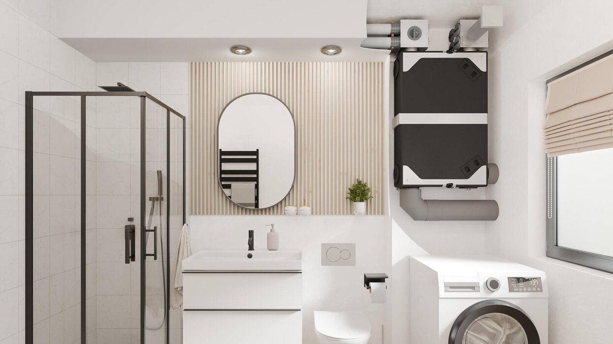 Das Bild zeigt ein modernes Badezimmer mit Dusche, Waschmaschine und einem kompakten Lüftungsgerät, das platzsparend an der Wand montiert ist.