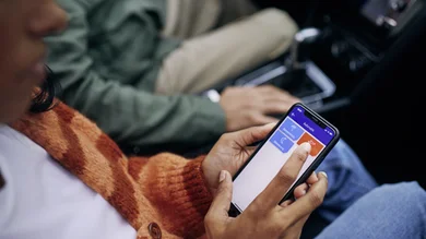 Das Bild zeigt mehrere Personen, die jeweils ein Smartphone in der Hand haben. Der Fokus liegt auf den Händen.