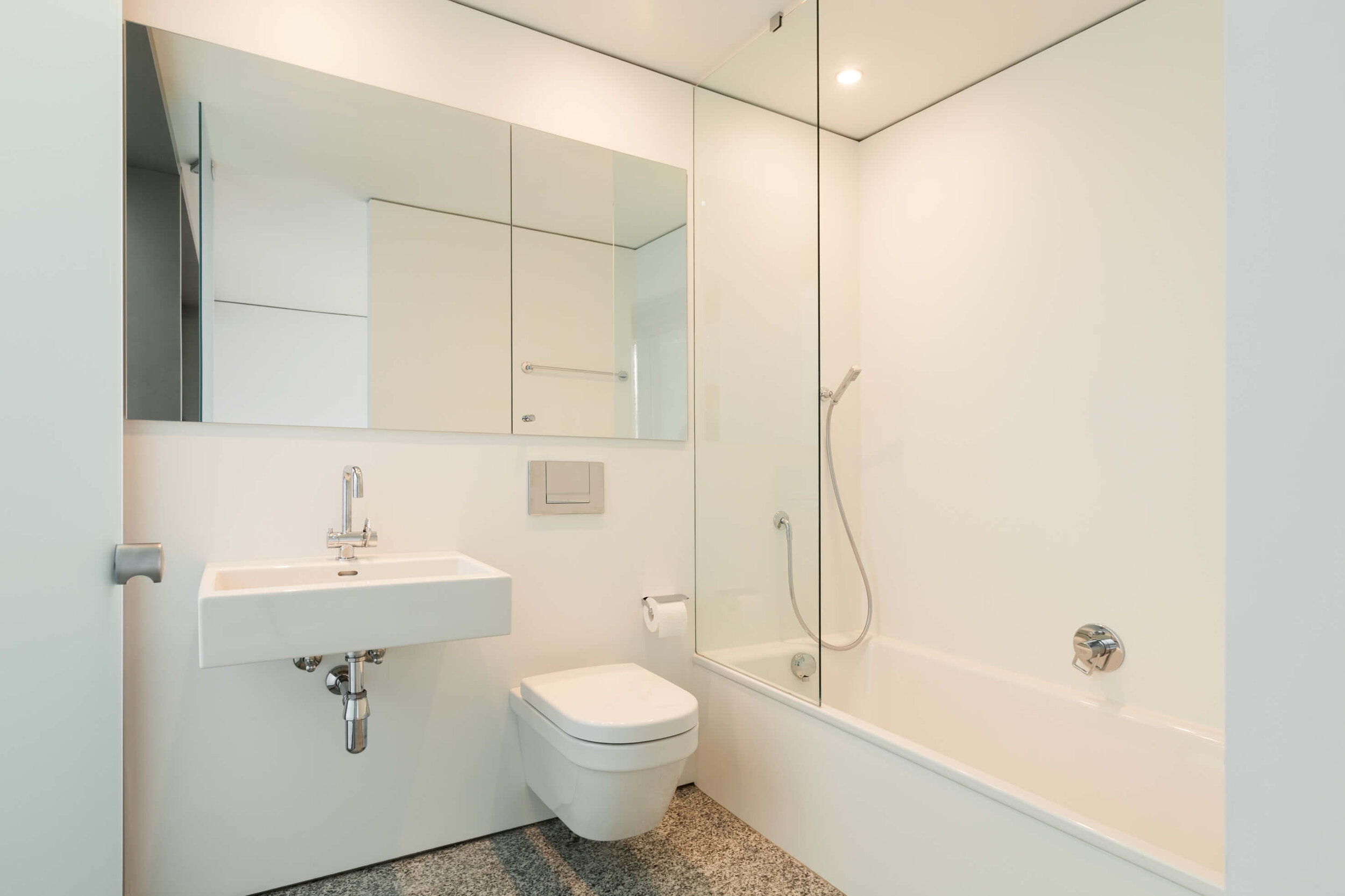 Dieses Bild zeigt ein modernes und funktionales Badezimmer, fast komplett in der Farbe weiß gehalten.