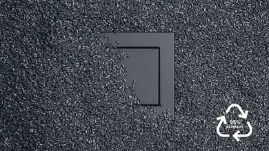 Schalter in der Farbe Grau des Herstellers Jung. Der Schalter ist mit feinen grauen Körnern zur Hälfte bedeckt.