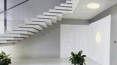 Das Bild zeigt eine moderne Treppe. Unter dem Treppenabsatz und an der Wand unter Treppe sind runde Leuchten angebracht. 