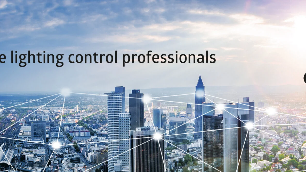 Das Bild zeigt eine Stadtansicht mit modernen Hochhäusern, die durch Striche verbunden sind. Im oberen linken Bereich des Bildes ist das Logo von B.E.G in Kombination mit dem Text "The lighting control professionals" abgebildet. In der rechten oberen Ecke ist das Logo für KNX eingebunden. 