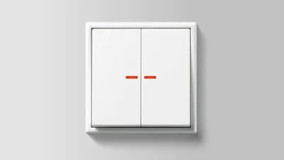 Einzelansicht eines Doppelschalters in der Farbe Weiß des Herstellers Jung vor einem grauen Hintergrund.