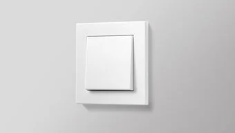 Schalter in der Farbe Weiß des Herstellers Jung an der grauen Wand montiert.