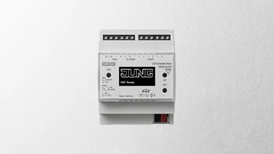 Einzelansicht eines KNX LED Controllers des Herstellers Jung in der Farbe Weiß vor einem grauen Hintergrund.