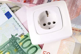 Das Bild zeigt symbolhaft Strom- und Geldsparen. Es sind eine Steckdose und verschiedene Eurobanknoten zu sehen.