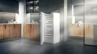 Moderne Küchenzeile mit weißem Stand-Gefrierschrank, der halb offen steht, von Liebherr.