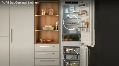 Geöffnete Kühl- und Gefrierschrankkombination von Liebherr als Einbaugerät integriert in eine Küchenzeile.