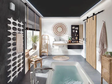 Modern gestaltetes Badezimmer mit Badewanne, Waschbecken, Holz- und Rattanelementen sowie dekorativen Details. Ein Lüfter ist oben links an der Wand installiert.