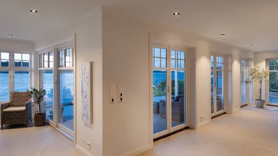 Blick auf eine moderne Wohnfläche mit Fenstern und Beleuchtung.