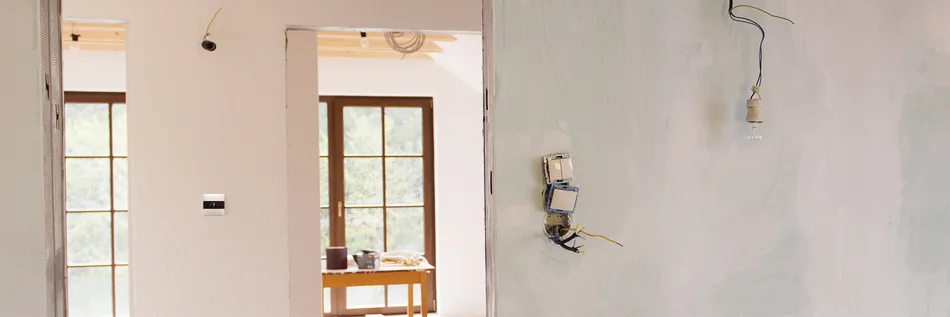 Das Bild zeigt einen hellen und modernen Wohnraum mit Fenstern im Hintergrund.