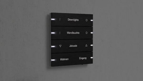 Das Bild zeigt einen dubklen 4-fach Tastschalter an einer dunklen Wand.