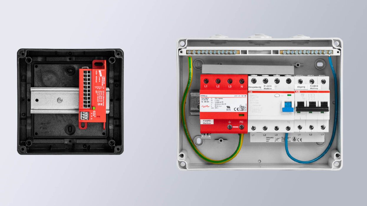 Zu sehen sind zwei geöffnete Elektrogehäuse mit installierten elektrischen Komponenten, darunter Sicherungs- und Schutzmodule sowie farbige Anschlussleitungen, vor hellem Hintergrund.