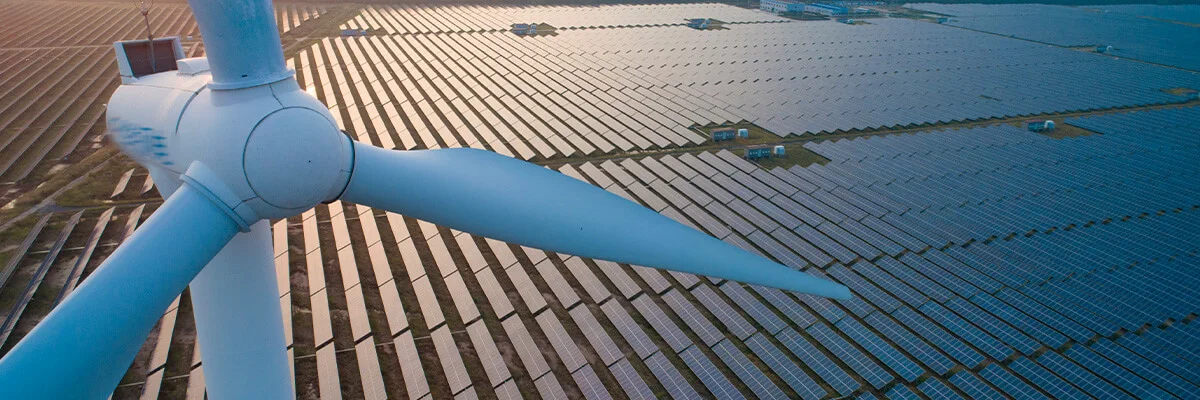 Windrad von oben und im Hintergrund viele Photovoltaikanlagen.