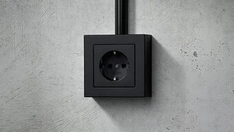 Steckdose in der Farbe Schwarz des Herstellers Jung an der Wand montiert.