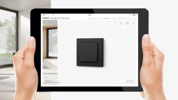 Person hält ein Tablet vor sich Es sind beide Hände zu sehen. Auf dem Display ist ein Schalter in der Farbe Schwarz zu sehen.