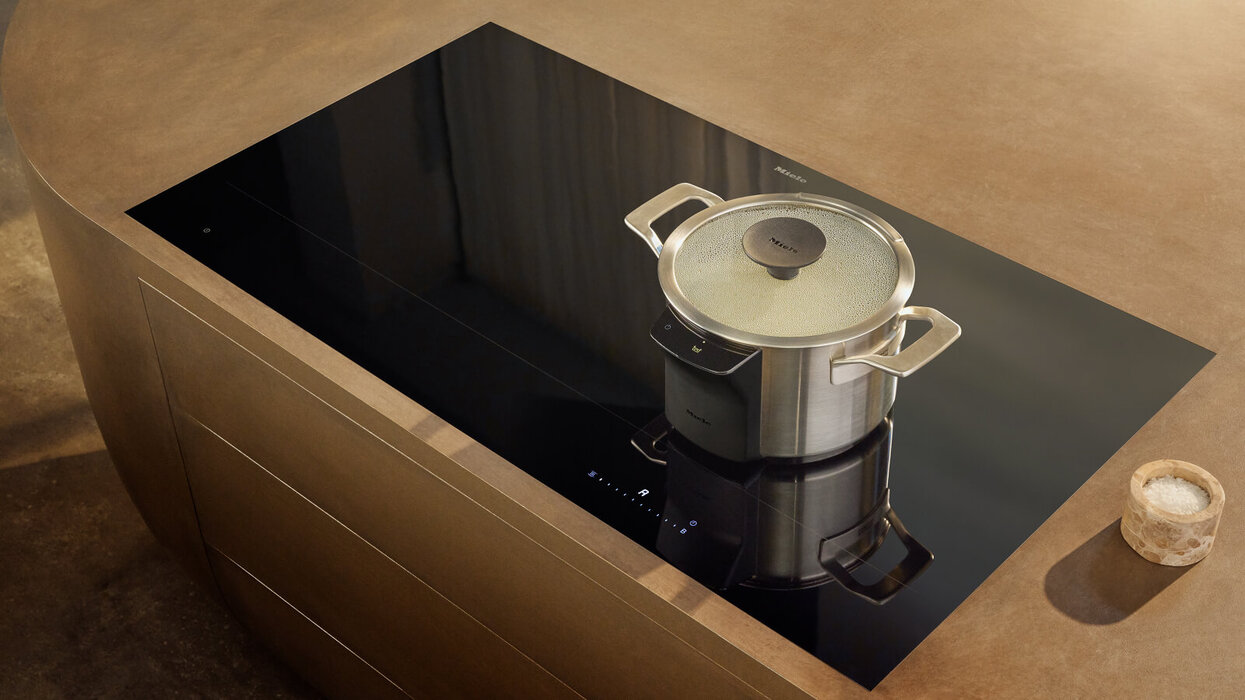 Das Bild zeigt einen Topf auf einem Induktionskochfeld von schräg oben.