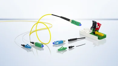 Einzeldarstellung verschiedener Stecker in den Farben Grün und Blau. Dazu ein gelbes Kabel mit grünem Stecker vor hellem Hintergrund.