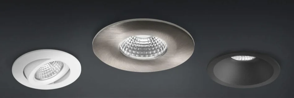 Drei moderne, runde LED-Einbauleuchten in unterschiedlichen Farben, die bündig in eine dunkle Decke eingelassen sind