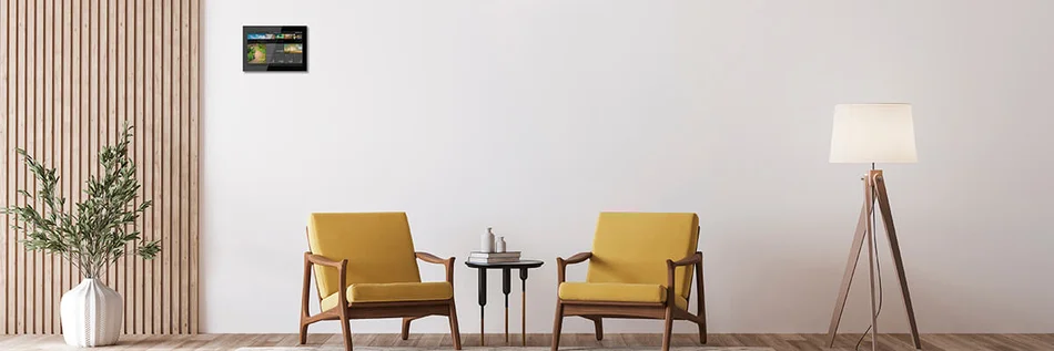 Das Bild zeigt zwei Sessel . Über dem linken Sessel hängt ein schwarzes Busch-SmartTouch® an der Wand. 