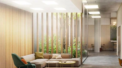 Das Bild zeigt ein modernes, lichtdurchflutetes Büro mit großen Glasflächen, Holzlamellen und viel Grün. Quadratische, flache Deckenleuchten sorgen für eine gleichmäßige und angenehme Beleuchtung im Raum.