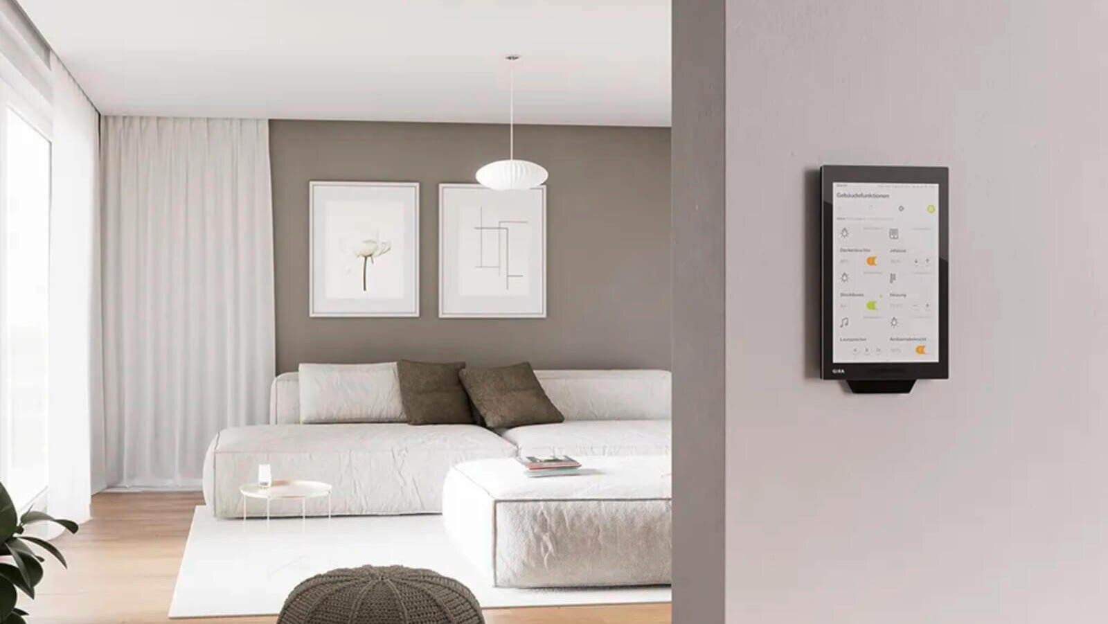 Das Bild zeigt ein modernes Wohnzimmer mit einem großen, hellen Sofa und minimalistischer Dekoration. An der Wand ist ein Smart-Home-Bedienpanel mit einer Benutzeroberfläche zur Steuerung verschiedener Funktionen angebracht.