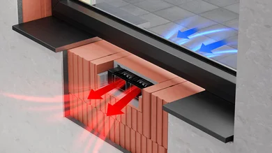 Das Bild zeigt einen Querschnitt einer Wand mit eingebautem Lüftungsgerät unter einem Fenster. Blaue Pfeile deuten auf einströmende Außenluft hin, rote Pfeile zeigen die Verteilung der erwärmten Luft ins Rauminnere.