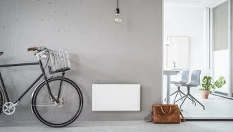 neben einem Fahrrad ist ein Heizkonvektor an der Wand befestigt.