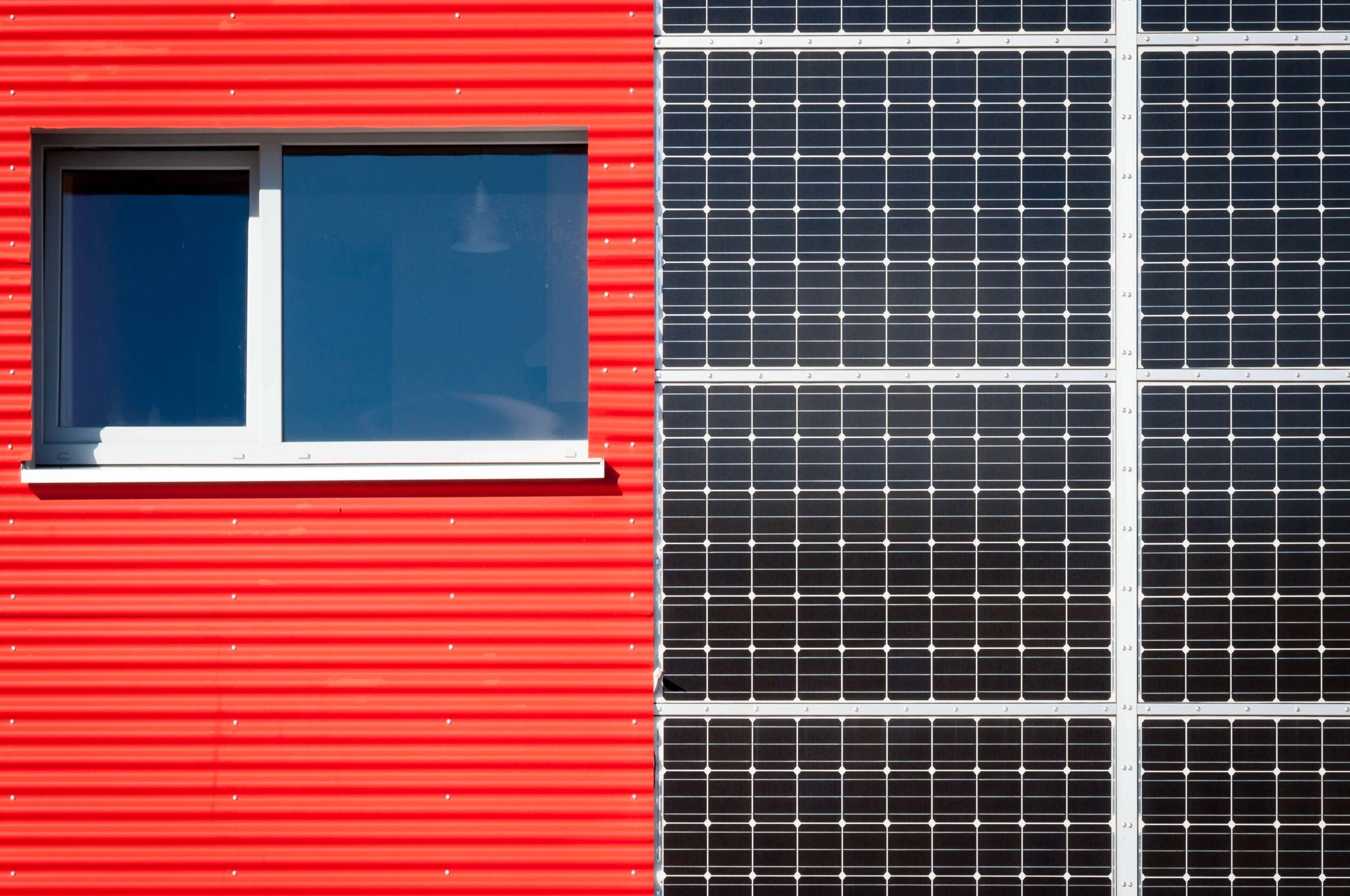 Das Bild zeigt eine Photovoltaikfassade an einer Fassade in der Farbe Rot.