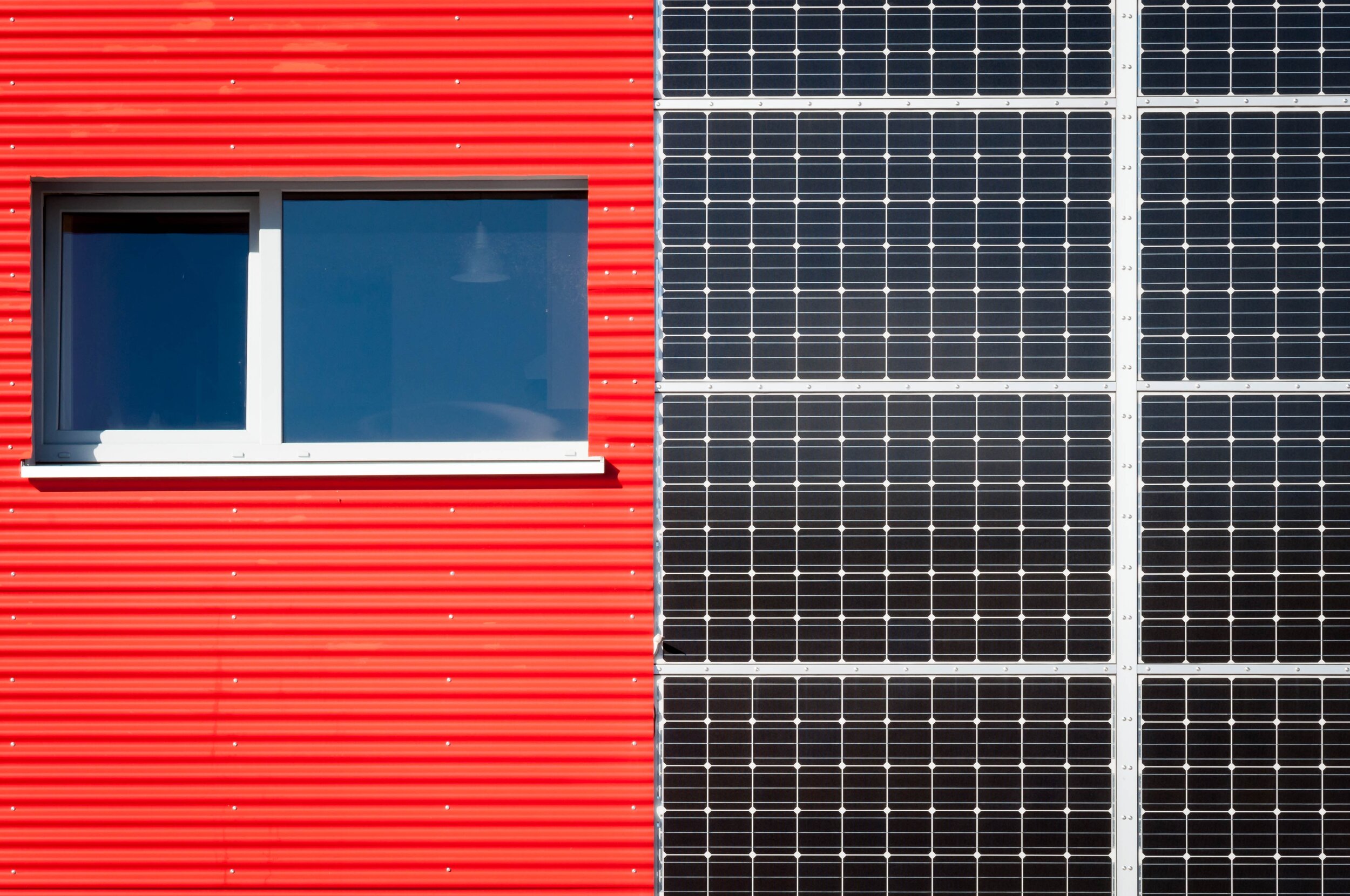 Das Bild zeigt eine Photovoltaikfassade an einer Fassade in der Farbe Rot.