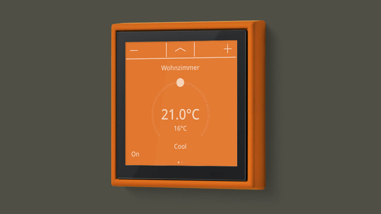 Helles Touch-Bedienfeld in der Farbe Orange vor einem grauen Hintergrund.