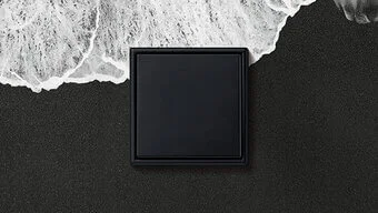 Schalter in der Farbe Schwarz des Herstellers Jung an der schwarz-weißen Wand montiert.