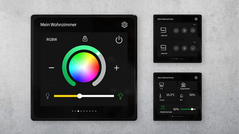 Zu sehen sind drei schwarze KNX-Touchpanels zur Smart-Home-Steuerung, darunter ein großes Hauptdisplay mit Farbrad für RGBW und zwei kleinere Bedienfelder rechts.