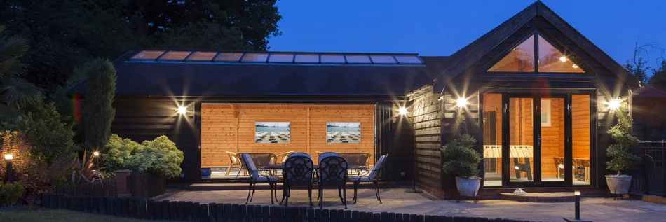 Sicht auf die Front eines Einfamilienhauses mit Beleuchtung in der Dämmerung.