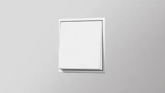 Schalter in der Farbe Weiß des Herstellers Jung an der grauen Wand montiert.
