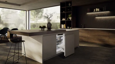 Moderne Küche mit großer Kochinsel, dunklen Holzmöbeln und raumhohen Fensterflächen. In die Insel ist ein geöffneter Unterbau-Kühlschrank integriert.