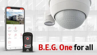 Das Bild zeigt einen Präsenzmelder, ein Smartphone und den Adapter für die B.E.G. One.