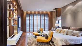 Bild zeigt ein Schlafzimmer im edlen Ambiente mit zwei gelben Stühlen vor dem Bett und einer stimmungsvollen Beleuchtung.