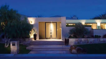 Modernes Wohngebäude von außen in der Dämmerung mit Beleuchtung.