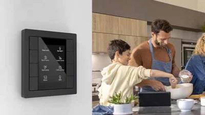 3 Person, davon ein Kind kochen zusammen. Im Vordergrund ist ein Tastsensor in Schwarz zu sehen, der an der Wand montiert ist.