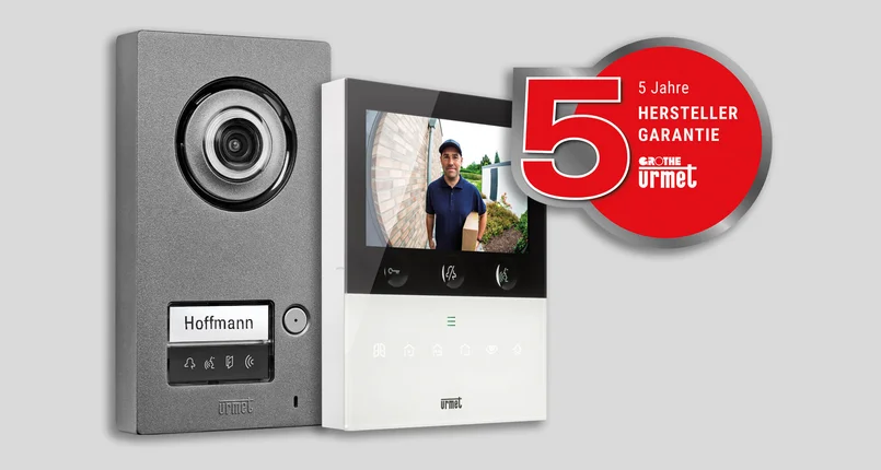 Das Bild zeigt eine moderne Video-Türsprechanlage mit Außenkamera und Innenmonitor, auf dem ein Lieferant zu sehen ist. Rechts daneben ist ein rotes Label mit "5 Jahre Herstellergarantie" und den Logos von Grothe und Urmet abgebildet.