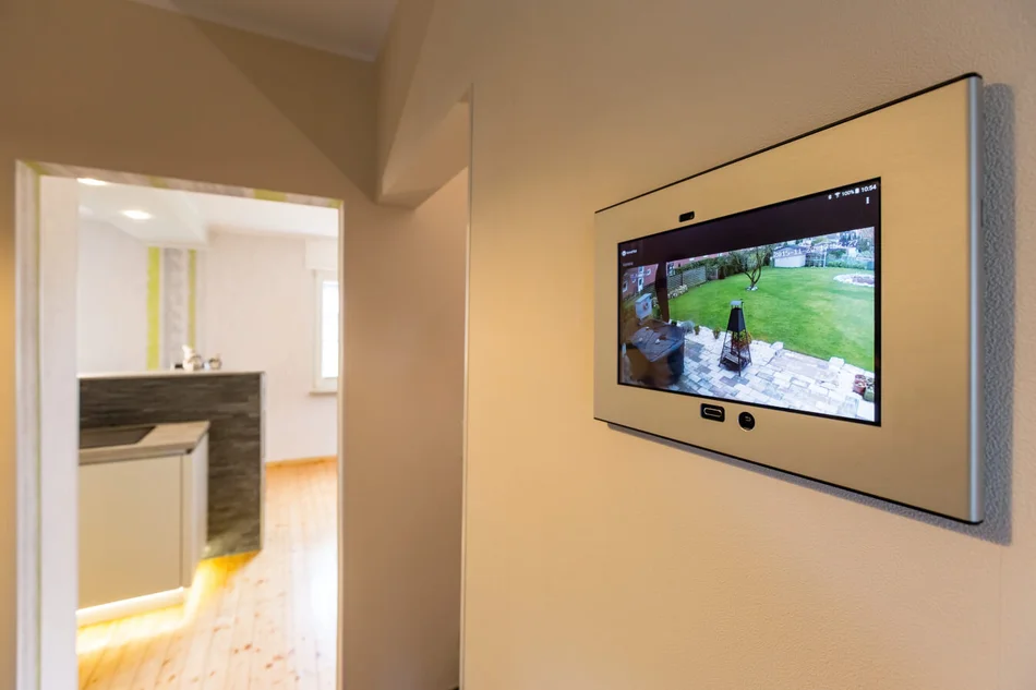 Moderner Flur mit großem Display zum Steuern des Smart Home und Sicherheitselementen.