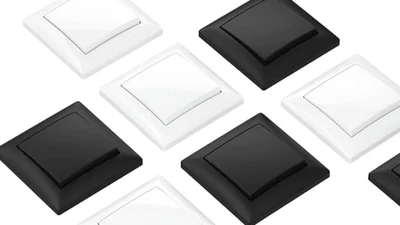 Das Bild zeigt mehrere quadratische Wandschalter in Schwarz und Weiß, schräg angeordnet auf weißem Hintergrund.