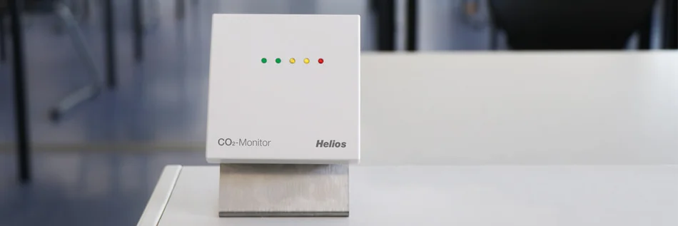 Das Bild zeigt in Großaufnahme einen weißen CO2-Monitor, der auf einem Tisch steht.