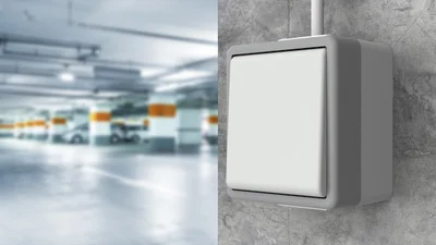 Schalter Delta, der an einer Wand montiert ist. Im Hintergrund ein Parkhaus von innen. 